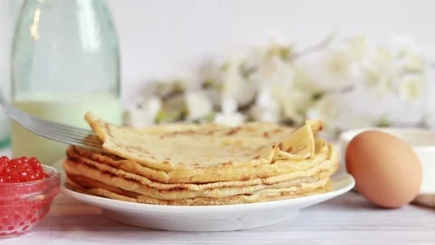 A stack of hot pancakes. Put a new crepes on a stack of ready-made pancakes Stock Footage 234192923