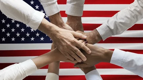 Stack of human hands over animated waving USA or American flag. Concept of union Stock Footage 122049634