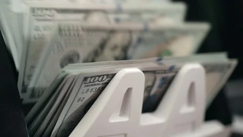 Stack of hundred-dollar bills being counted in a cash handling machine, Stock Footage 331079825