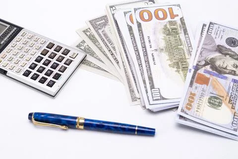 Stack of Hundred Dollar Bills with Calculator and Pen on White Background. Stock Photos