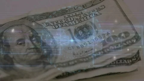 Stack of hundred-dollar bills emerging under HUD scan, showing serial Stock Footage 330330704