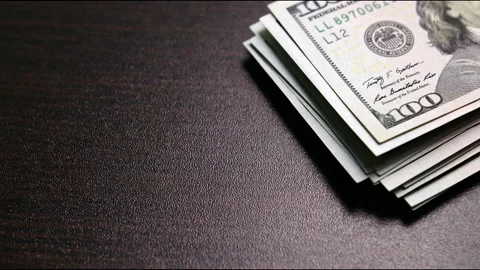 Stack of hundred-dollar bills on table Stock Footage 149022672