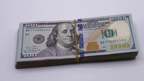 Stack of hundred-dollar bills on a table. Transition from lights off to lights Stock Footage 319292162