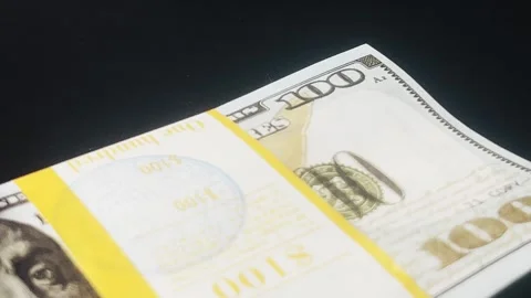 A stack of hundred-dollar bills is taken from the black table. Stock Footage 288170900