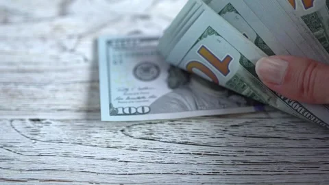 A stack of hundred dollar bills in a woman's hand. Stock Footage 327177268