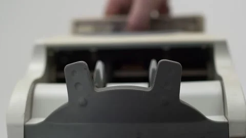 Stack of hundred dollars bills is inserted into the counting machine with hand Stock Footage 150622303