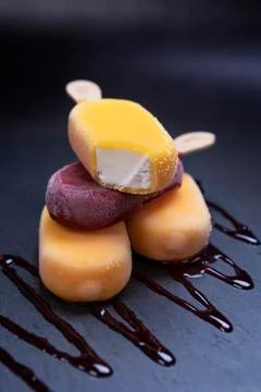 Stack of ice cream stick placed on a black stone background Фото