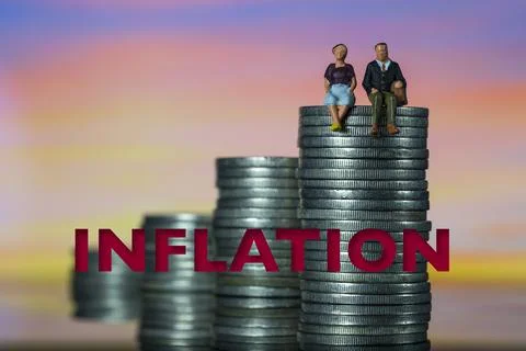 Stack of increasing coins showing the word INFLATION miniature couple sitting Stock Photos