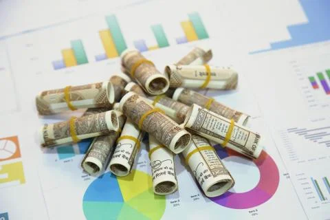 Stack of Indian 10 rupee currency note rolls on the chart paper Stock Photos