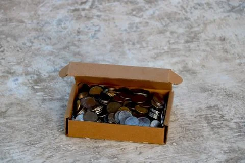 Stack of Indian coins in brown paper box Stock Photos