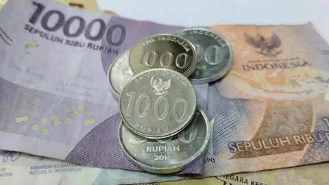 A stack of Indonesian currency made of metal and one made of paper 스톡 동영상 285591934