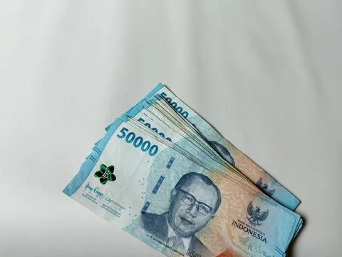 Stack of Indonesian fifty thousand rupiah banknotes arranged on a clean white Foto stock