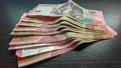 Stack of Indonesian Rupiah 100000 Banknotes on Dark Wooden Table Stock Photos
