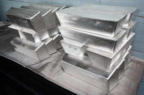 Stack of industrial silver ingots at bright light in storage Stock Photos