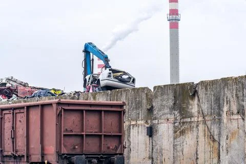 A stack of iron loaded on a train and a smoking chimney Foto stock