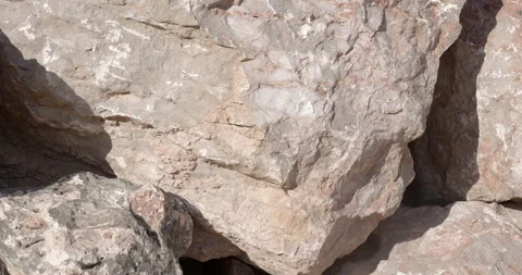 Stack of jagged rough rocks with cracks and crevices in bright sun Stock Footage 314524662