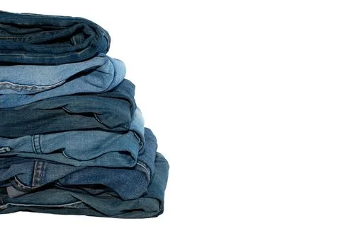 A stack of jeans in different colors on a white background. Jeans isolate Stock Photos