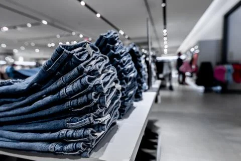 Stack of jeans in the store. Shopping mall. Shopping concept. Stock Photos