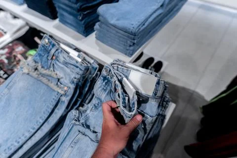 Stack of jeans in the store. Shopping mall. Shopping concept. Stock Photos