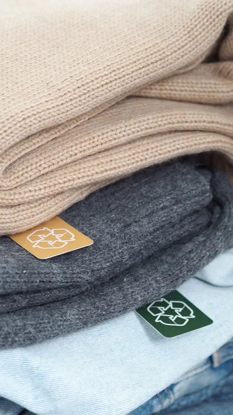 A stack of jeans, sweaters with a label for recycling. Clothes for recycling. cl Stock Footage 281340423