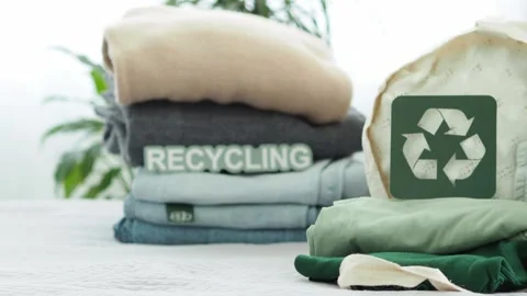 A stack of jeans, sweaters with a label for recycling. Clothes for recycling. cl Stock Footage 281340519