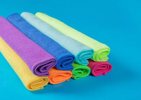 Stack of kitchen microfiber towels in bright colors on a blue background Stock Photos