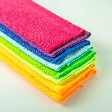 Stack of kitchen microfiber towels in bright colors on a light mirror background Stock Photos
