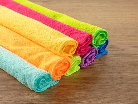 Stack of kitchen microfiber towels in bright colors on a brown wooden table Stock-Fotos