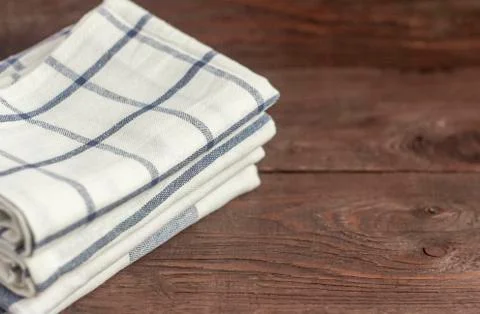 A stack of kitchen towels are stacked on an old rustic table. Stock Photos