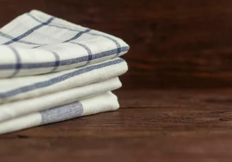 A stack of kitchen towels are stacked on an old rustic table. Foto stock