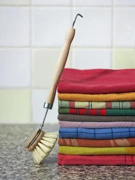Stack of kitchen towels with dish-washing brush 스톡 사진