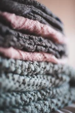 Stack of knitte clothes closeup. Winter season. Selective focus. Stock Photos