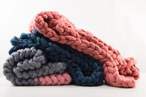 A stack of knitted blankets from natural materials on a white background concept 스톡 사진