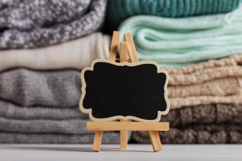 A stack of knitted clothes of different colors and textures, on the table nex Stock Photos