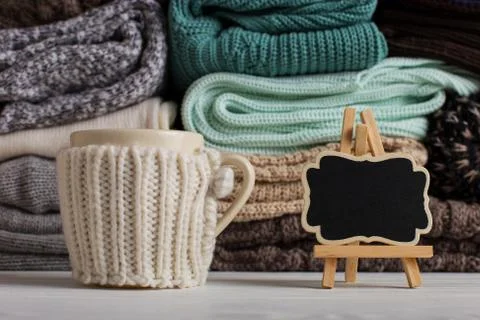 A stack of knitted clothes of different colors and textures, on the table nex Stock Photos