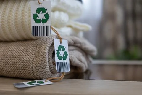 A stack of knitted clothes made from natural wool. Biodegradable, eco-friendly Stock Photos