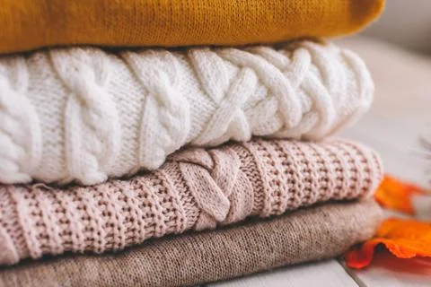 A stack of knitted sweaters close up. Stock Photos