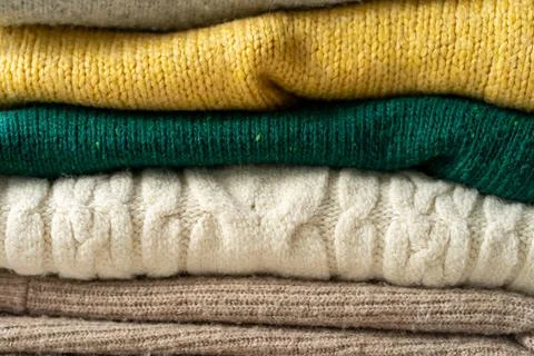 A stack of knitted sweaters on the table. Background textures Stock Photos