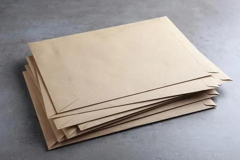 Stack of kraft paper envelopes on grey table 写真素材