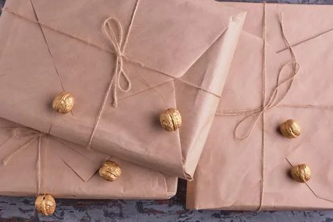 A stack of kraft paper parcels decorated with Christmas tree golden nuts. P.. Stock Photos