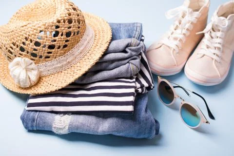 Stack of ladies summer clothes  and accessories.  Jeans overalls, glasses, Foto stock
