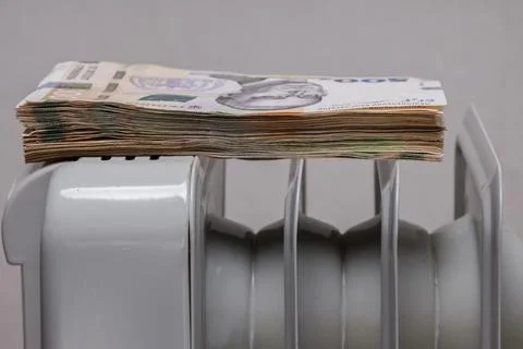 Stack of large banknotes on a heating radiator Stock Photos