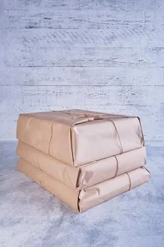 A stack of large classic-looking parcels wrapped in kraft paper and tied with Stock Photos
