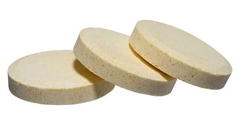 Stack of large round pills of light yellow color, isolated background Stock-Fotos