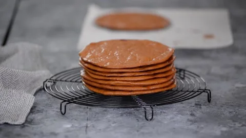 A stack of layers cakes for caramel cake on cooling rack. Stock Footage 151682577