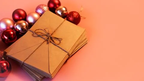 Stack of letters from craft paper with christmas red and pink balls Stock Photos