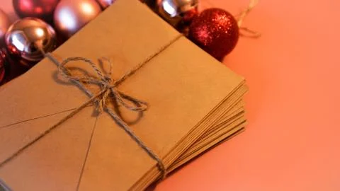 Stack of letters from craft paper with christmas red and pink balls 스톡 사진