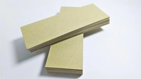 Stack of light brown paper sheets on white background. Stock Photos