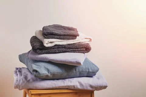 A stack of linen textiles on a small wooden chair Foto stock