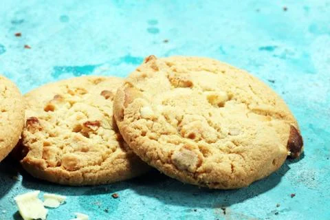 Stack of macadamia nut and white chocolate cookies on table with chocolate ch Stock Photos
